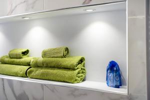 three towels on a shelf in a bathroom at Il ciliegio di Miki in Genova