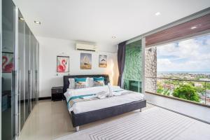 Patong Villa1三卧泳池别墅两个海景房 近班赞江西冷海滩中文管家 في شاطيء باتونغ: غرفة نوم بها سرير ونافذة كبيرة +62 صورة