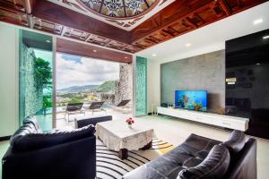 Patong Villa1三卧泳池别墅两个海景房 近班赞江西冷海滩中文管家 في شاطيء باتونغ: غرفة معيشة بها أريكة وطاولة