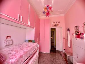una camera rosa con letto e lampadario pendente di Notti magiche a Santa Margherita ligure a Santa Margherita Ligure