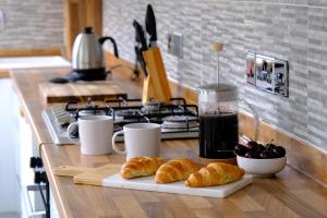 a kitchen counter with croissants and a drink on a table at Beautiful Cottage with Sea Views Cornwall in Saltash