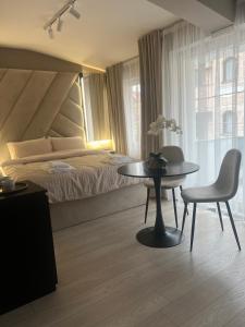 a bedroom with a bed and a table and a chair at Kali Apartments in Bitola