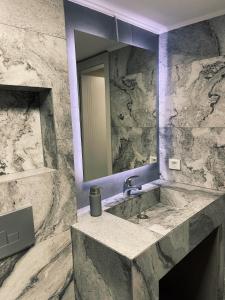 a bathroom with a marble sink and a mirror at Kali Apartments in Bitola +29 photos