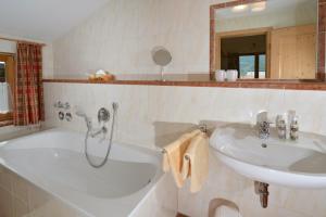 a white bathroom with a sink and a tub and a sink at Residenz Sonnwinkl in Reit im Winkl +11 photos