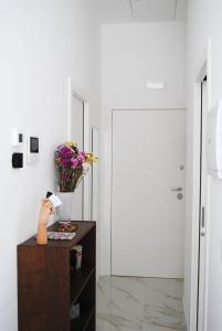 a room with a table with a vase of flowers on it at Kisto a casa in Bari