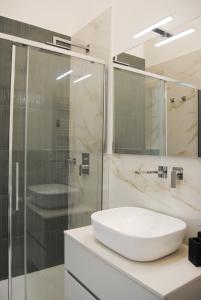 a bathroom with a sink and a glass shower at Kisto a casa in Bari +7 photos