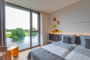 a bedroom with two beds and a large window at LAGO hotel & restaurant am see in Ulm