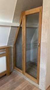 a wooden cabinet with glass doors in a room at Het Heertje in Den Hoorn
