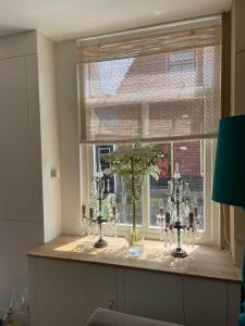 een kamer met een raam met een vaas op een tafel bij Het Heertje in Den Hoorn