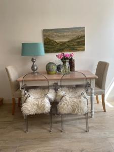 a dining room table with chairs and a table with a lamp at Het Heertje in Den Hoorn