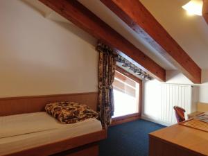 a bedroom with a bed and a window at Hotel Fortini in Madonna di Campiglio