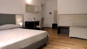 a bedroom with a bed and a desk and a table at B&B Villa Mariotta in Amantea