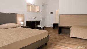 a hotel room with two beds and a desk at B&B Villa Mariotta in Amantea +10 photos