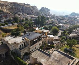 un antiguo edificio en una ciudad con una montaña en Canyon Cave Hotel en Ürgüp