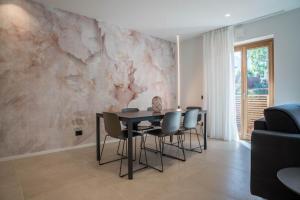 une salle à manger avec une table et des chaises contre un mur dans l'établissement Appartamento Midum Family Balcony, à Trente