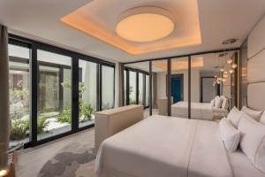 a bedroom with a large bed and large windows at The Westin Dragonara Resort, Malta in St. Julianʼs