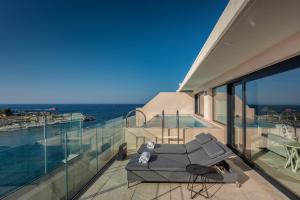 a house with a balcony with a view of the ocean at The Westin Dragonara Resort, Malta in St. Julianʼs
