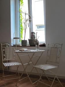 een tafel en twee stoelen voor een raam bij L'annexe 