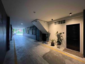 un corridoio di un edificio con porta e piante di arche second floor a Ban Riang