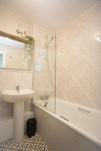 a white bathroom with a sink and a shower at Seaways Apartment in Worthing