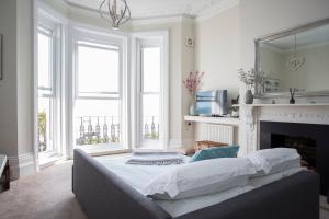 a bedroom with a large bed and a fireplace at Seaways Apartment in Worthing