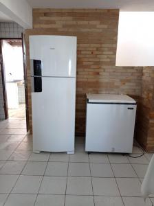 zwei weiße Kühlschränke in einer Küche mit Ziegelwand in der Unterkunft Casa de praia em Carapibus in Jacumã