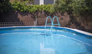 a blue swimming pool with two metal bars in it at TH46 Casa con piscina 900 m de la playa Arrebassada in Tarragona
