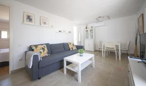 sala de estar con sofá azul y mesa en TH46 Casa con piscina 900 m de la playa Arrebassada en Tarragona