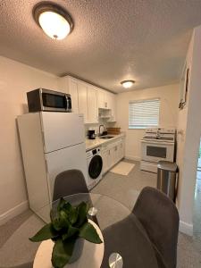 een keuken met een koelkast en een tafel en stoelen bij Cozy & Confy apt w/full kitchen for 4ppl in Fort Lauderdale
