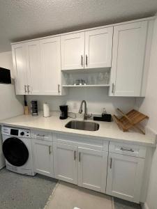een keuken met witte kasten en een wastafel bij Cozy & Confy apt w/full kitchen for 4ppl in Fort Lauderdale