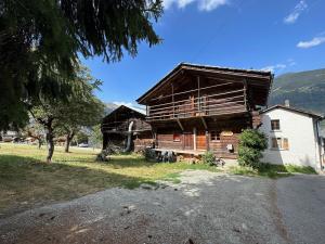 ein großes Holzhaus mit einem Baum davor in der Unterkunft Chalet Karibu - 4 Vallees - A 20 mns de Verbier in Bruson