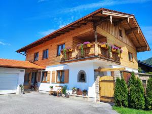 una casa con un balcón con flores. en Ferienwohnung Haindorfer Berg, en Aschau im Chiemgau