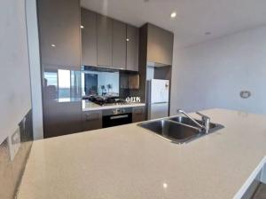 a large kitchen with a sink and a refrigerator at Quiet CBD 3b2b apartment + free parking in Melbourne