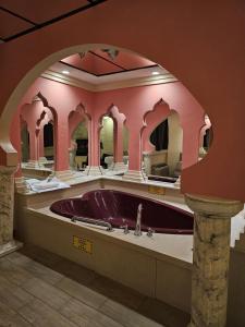 ein Badezimmer mit einer lila Badewanne in einem rosa Zimmer in der Unterkunft Loop Inn Motel in Avenel