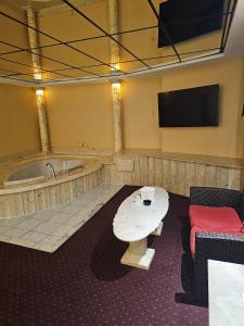 Zimmer mit Badewanne, Tisch und TV in der Unterkunft Loop Inn Motel in Avenel