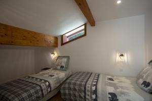 - une chambre avec 2 lits et une fenêtre sur le mur dans l'établissement Tignes Appartement 140 m2 pour 08-10 personnes, à Tignes