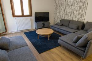 ein Wohnzimmer mit 2 Sofas, einem Tisch und einem TV in der Unterkunft Tignes Appartement 140 m2 pour 08-10 personnes in Tignes