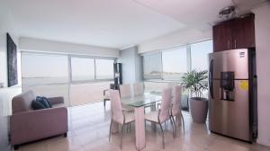 a kitchen and dining room with a table and a refrigerator at Suite 206, Riverfront, vista al río, Puerto Santa Ana, Guayaquil in Guayaquil