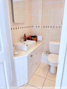 a bathroom with a white sink and a toilet at Portland House in Whitchurch
