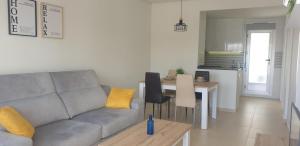 een woonkamer met een bank en een tafel bij Oasis Holiday House in Orihuela