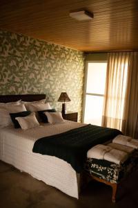 um quarto com uma cama grande e uma janela em Casa do Valle - Hotel Boutique em Chapada dos Guimarães