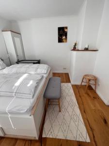 ein Schlafzimmer mit einem weißen Bett und einem Stuhl in der Unterkunft Obere Altstadt in Goslar