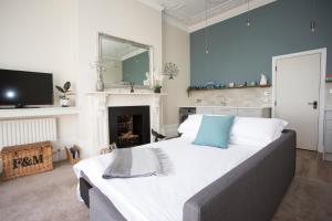 a bedroom with a large bed and a fireplace at Seaways Apartment in Worthing