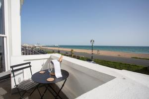a table on a balcony with a view of the beach at Seaways Apartment in Worthing