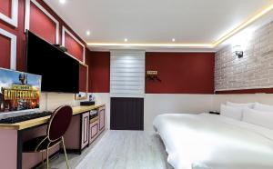 1 dormitorio con 1 cama y escritorio con ordenador en Hotel Cheese Ulsan Samsan en Ulsan