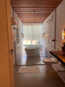 a bathroom with a tub and a toilet in it at Casa do Valle - Hotel Boutique in Chapada dos Guimarães