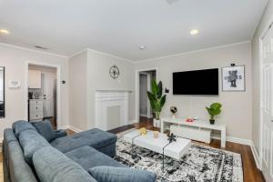 uma sala de estar com um sofá azul e uma televisão em Minutes away from Downtown area em Charlotte