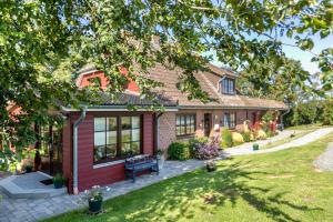 a red brick house with a bench in the yard at Ferienhaus Riedel in Galmsbüll