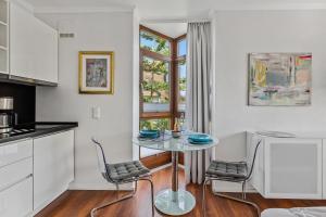 a kitchen with a table and two chairs and a window at Besilima Apartments Deidesheim - zentral & ruhig am Kurpark in Deidesheim
