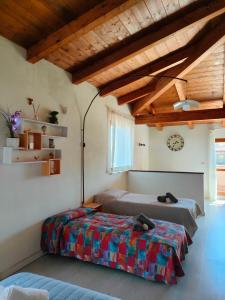 2 Betten in einem Zimmer mit Holzdecken in der Unterkunft Assisi il Panorama in Petrignano